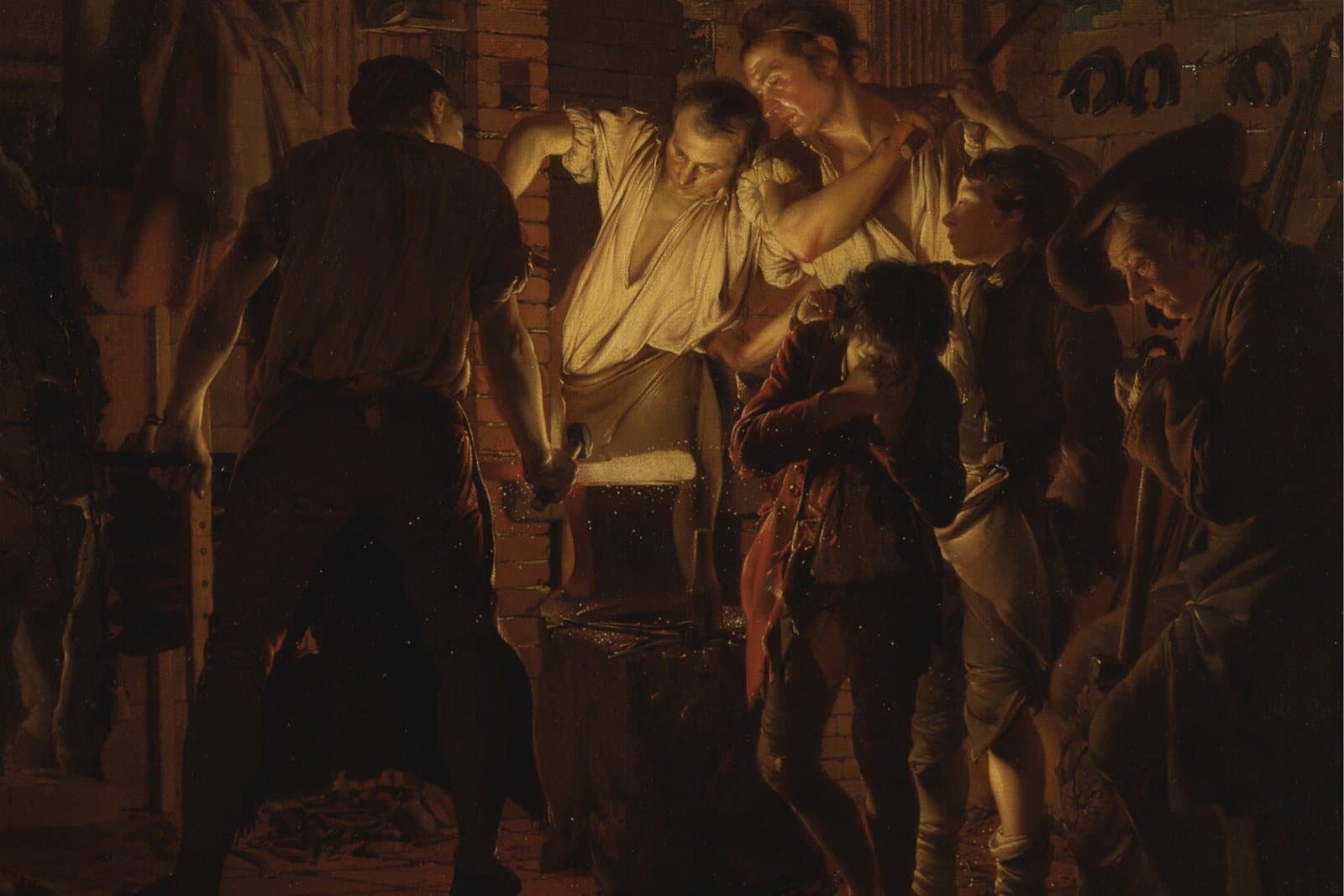 Night scene in a forge: a smith in a white shirt bends over a glowing bar of iron on the anvil while another man swings a hammer and children and an old man look on